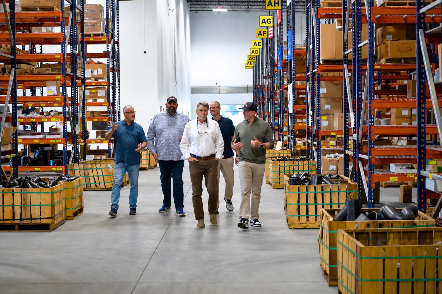 Business leaders walking through a large industrial distribution warehouse